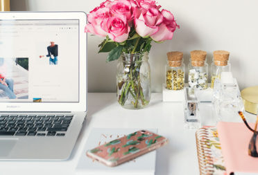 Laptop, roses, phone, notebook and desk decorations to embrace the remote work trend