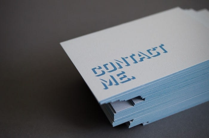 Pile of Luxe business cards with a blue edge with text saying Contact Me by Melanie Martin