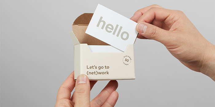 Hands holding MOO packaging with hello business card inside