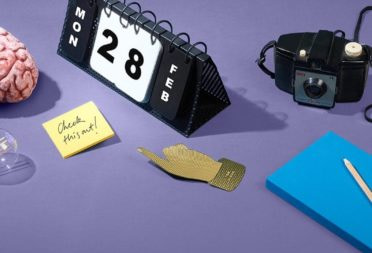 Brain, perpetual calendar and other accessories on a purple table