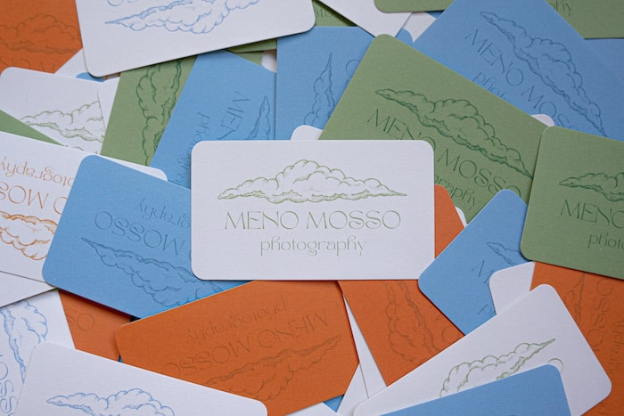 Blue, white, khaki and brick colored photographer business cards with a cloud illustration by photographer Emma Ogilvie from Meno Mosso