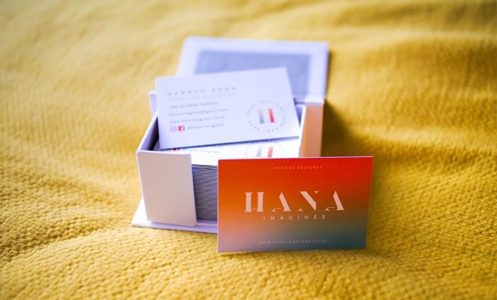 Box of orange and turquoise gradient business cards by Hana Imagines