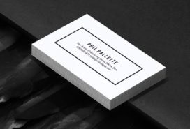 Pile of extra thick white business cards with a minimalist design making use of negative space