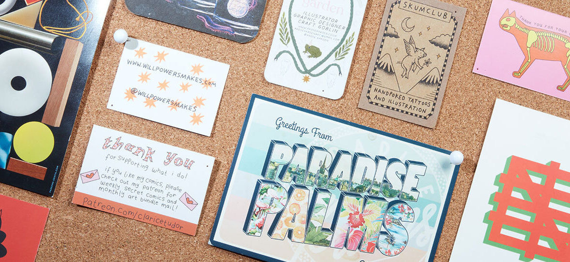Mosaic of print products on a cork board including a Paradise Palms postcard and various business cards
