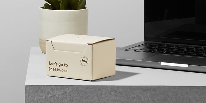 MOO packaging on a desk with a plant and a laptop