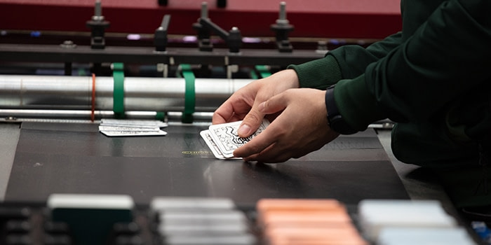Hands sorting business cards printed at the MOO printing facility