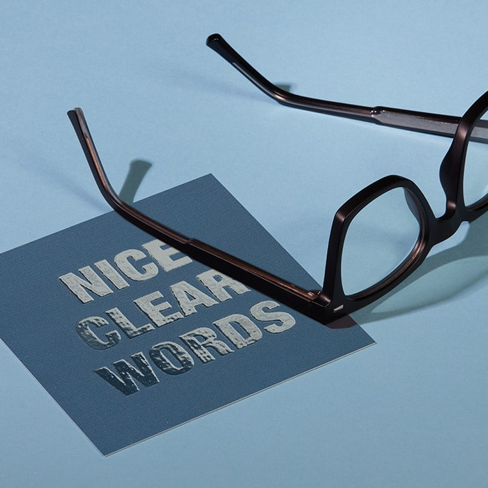 Square card with spot gloss finish saying Nice Clear Words next to a pair of glasses
