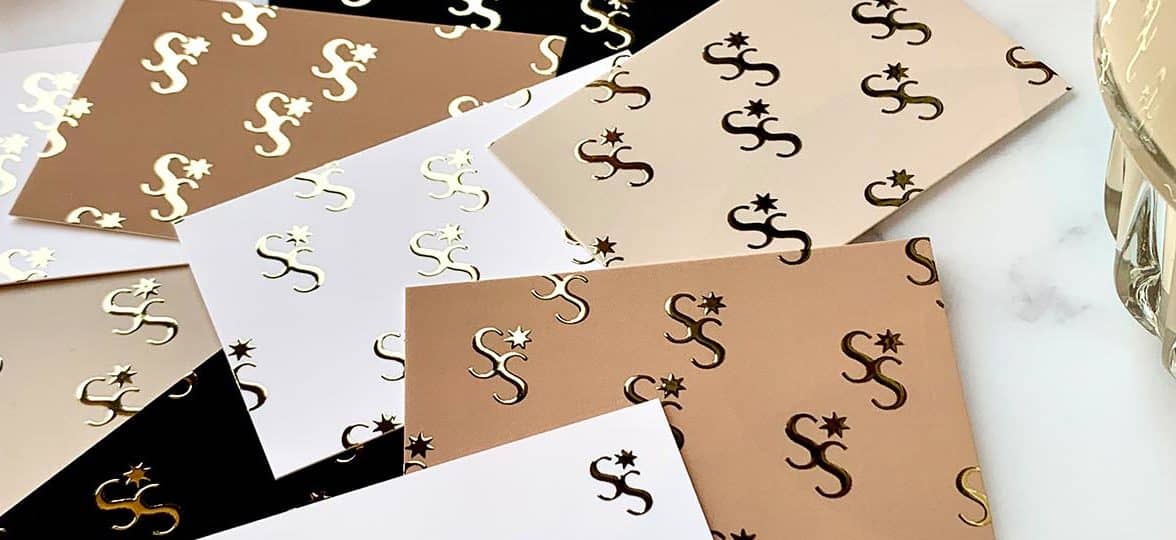 Tan, beige and white business cards with a gold foil logo by Spark Studio