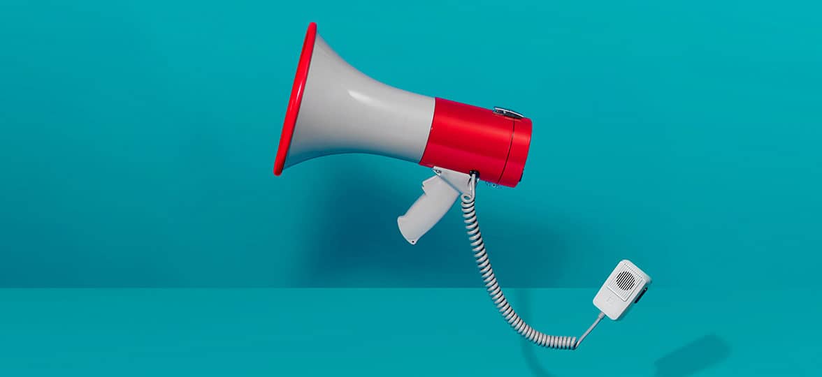 Red and grey megaphone on a turquoise background