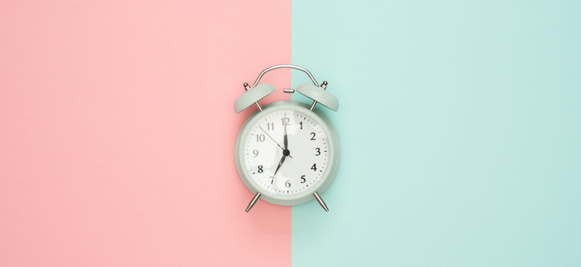 Alarm clock on pink and blue background