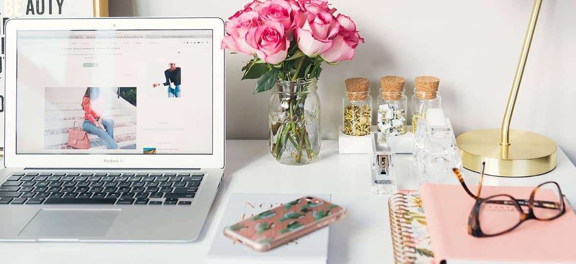 Laptop, roses, phone, notebook and desk decorations to embrace the remote work trend