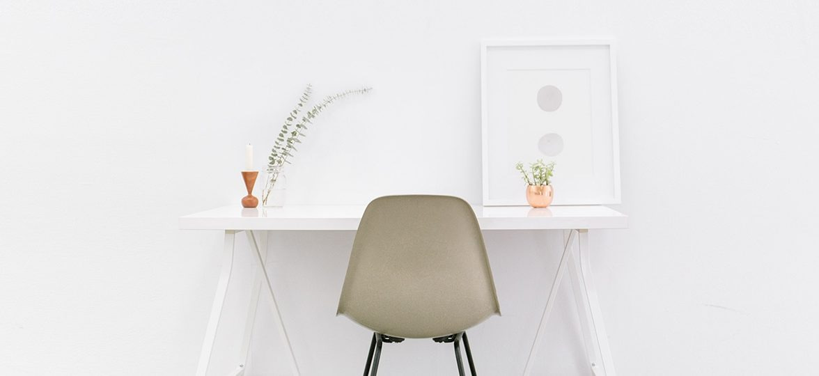 White desk, minimalist chair and framed poster