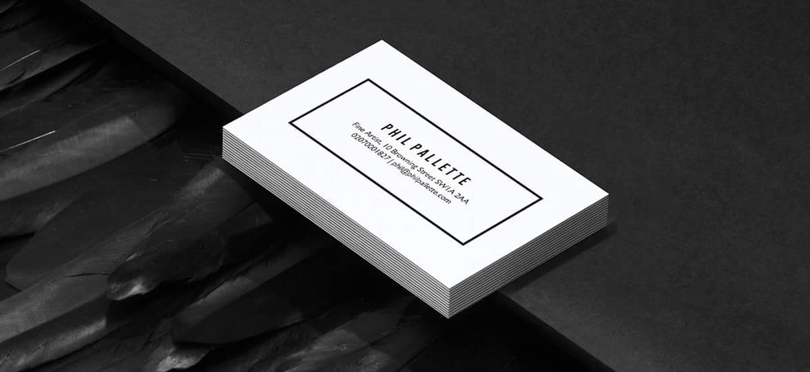 Pile of extra thick white business cards with a minimalist design making use of negative space