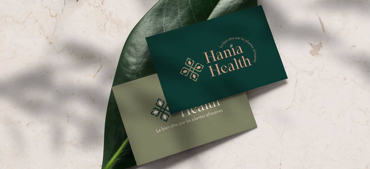 Two green business cards, one olive green and one dark pine green. They were designed by Roubina Tacorie for Hania Health