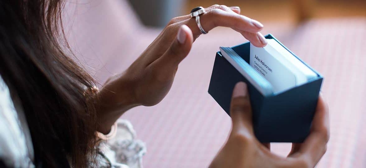 Person looking through their business cards in a display box