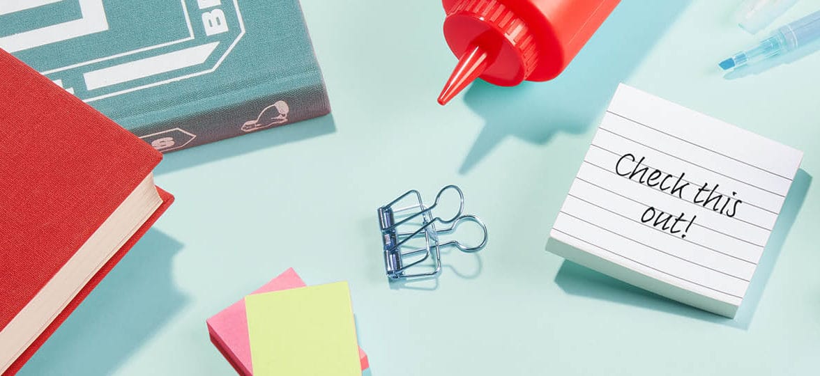 Notebooks, ketchup bottle and post it note saying "check it out"