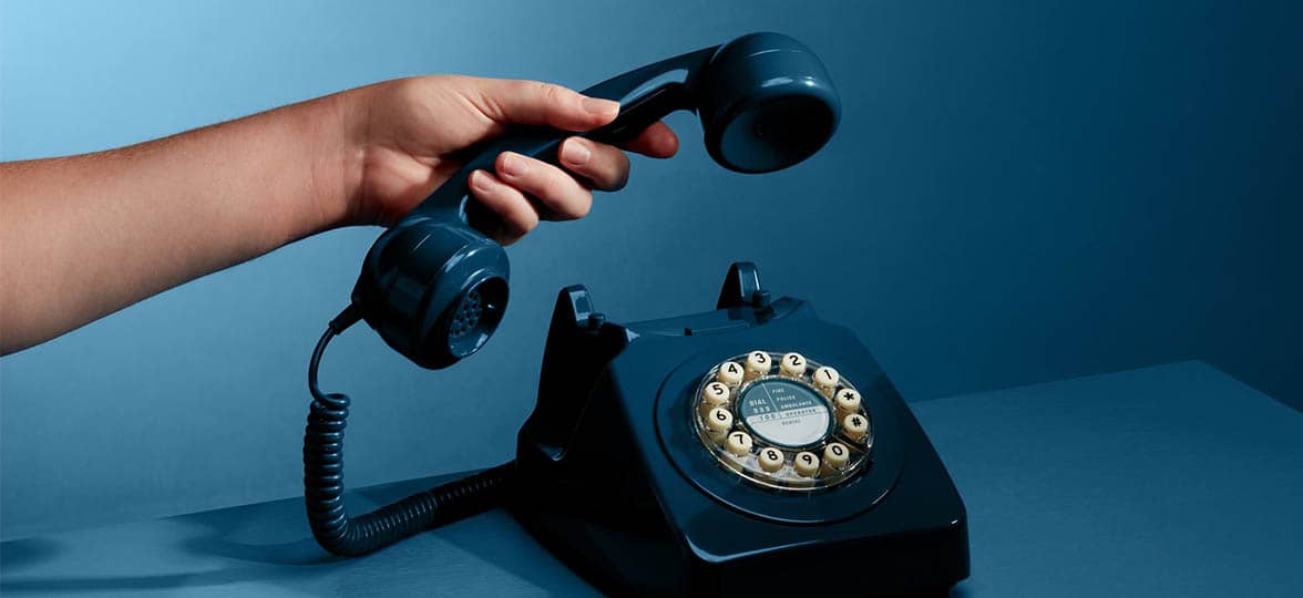 Hand picking up a blue phone to call MOO business services