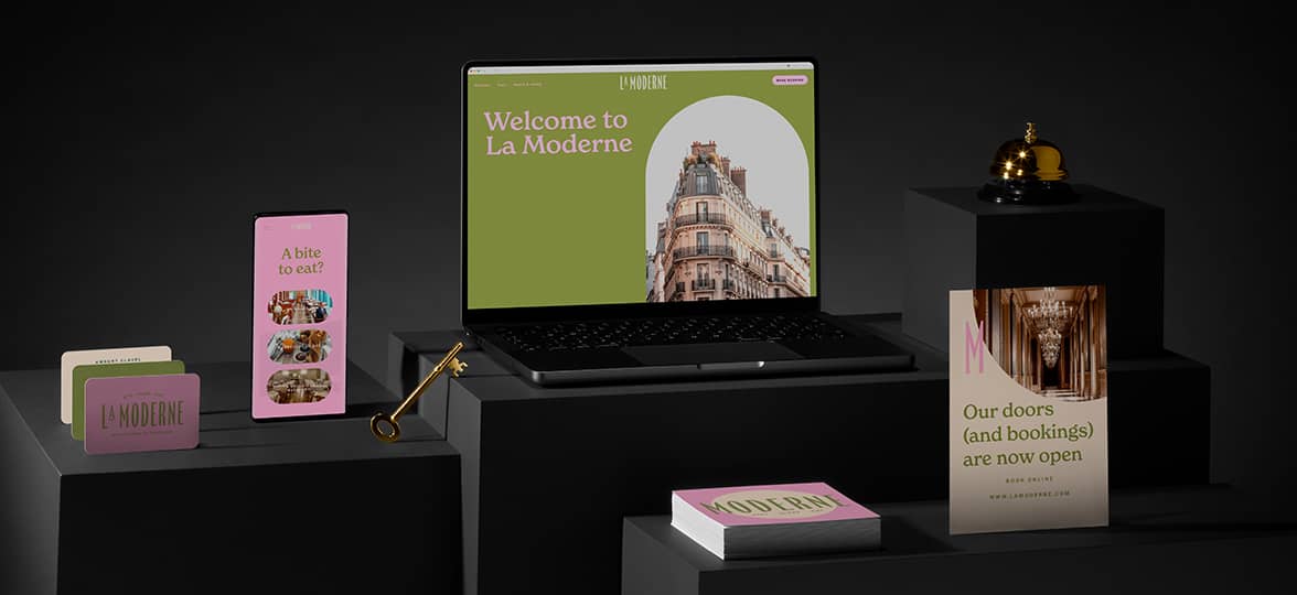 A suite of flyers, business cards, and square postcards for a modern hotel sit next to a lap top and cell phone showing matching branding on the hotel website built with Squarespace.