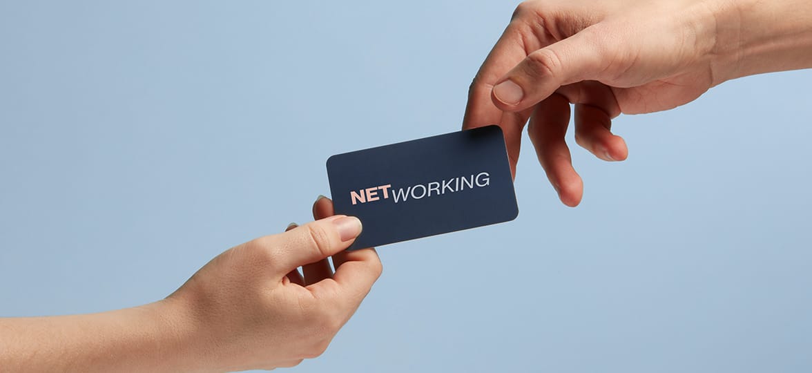Networking with a business card being handed to a potential client