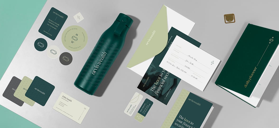 A suite of beautifully branded products laid out on a table, like water bottles, notebooks, envelopes, stickers, and business cards.