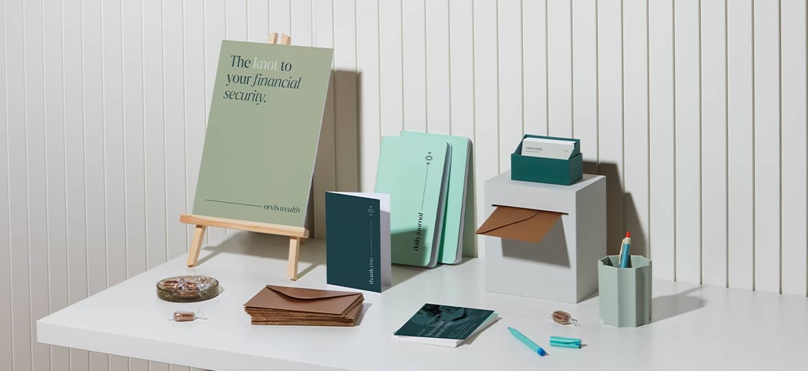 A display table at an event with notebooks, flyers, and marketing materials.