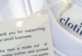 Close-up of Rue Clotilde white tshirt with hang tag explaining the sustainable production process