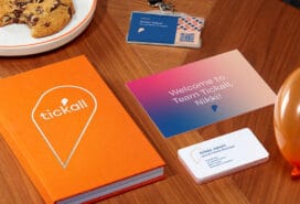 Photograph of Notebook, Postcards and Business Cards on table.