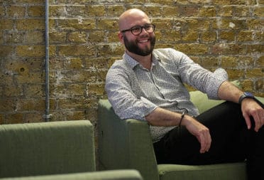 Portrait of Federico Franceschetti, senior software engineer at MOO, on a sofa