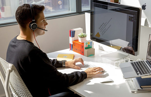 person at desk with headphones