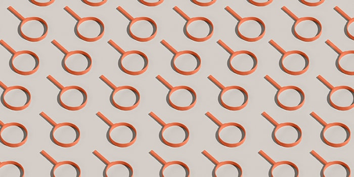 Orange magnifying glasses forming a pattern on a white background