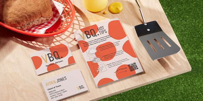 Flyer with cooking instructions and QR code business cards with a fun red dots design on a barbecue table by fake vegan brand VBQ