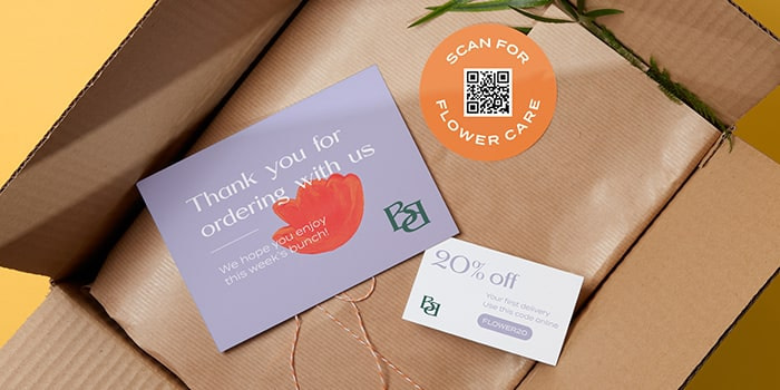 Mauve thank you postcard, 20% off coupon and round orange sticker with a QR code by fictional brand Best Buds