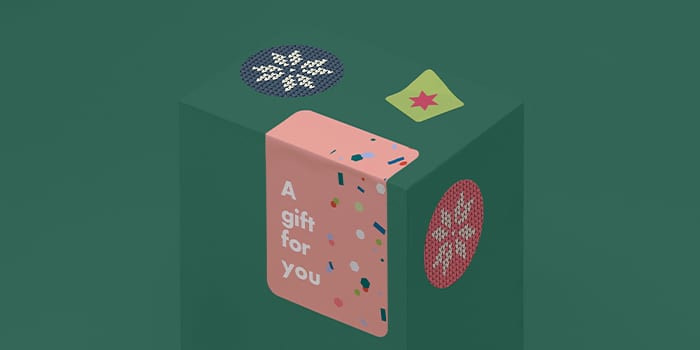 Rectangle with text saying a gift for you stuck on a green box with small round stickers and a mini square sticker