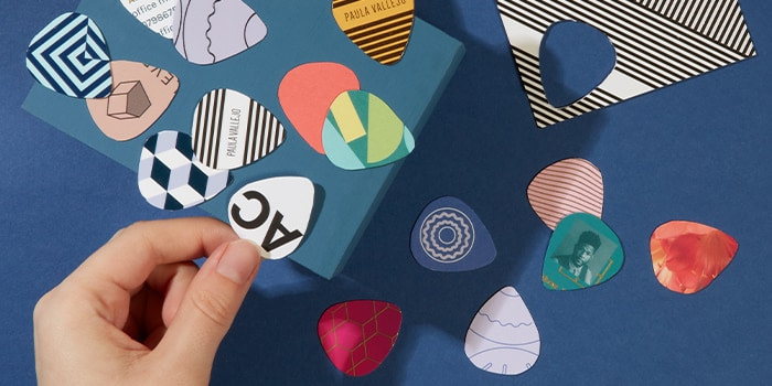 Many different colorful DIY guitar picks made of discarded business cards