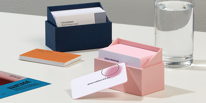 Two business card boxes in pink and dark blue