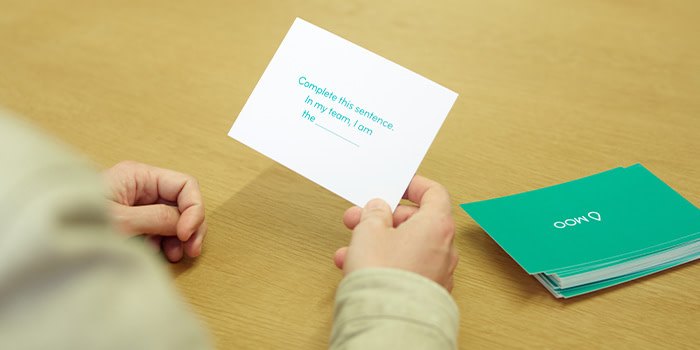 Hand picking a card asking to complete a sentence