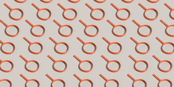 Orange magnifying glasses forming a pattern on a white background