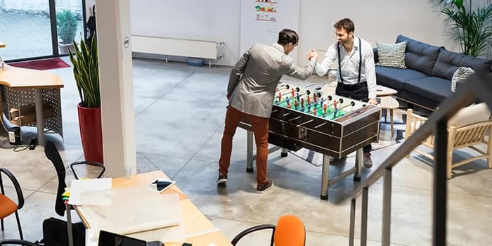 Two employees playing table football in the office