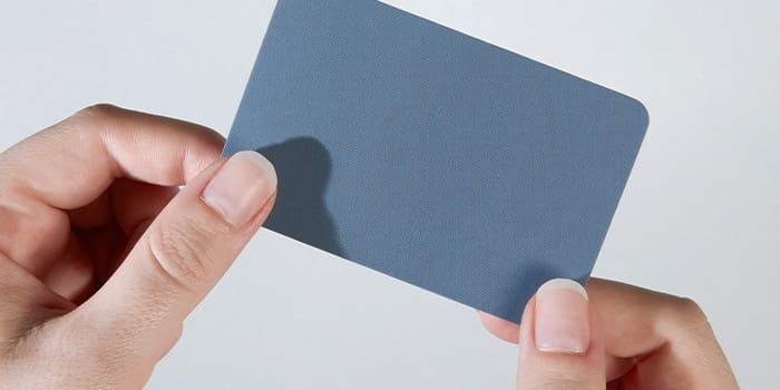 Grey business card held with two hands
