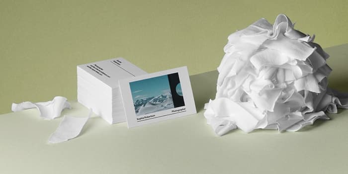 Pile of white tshirt scraps next to recycled cotton business cards