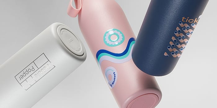Three MOO water bottles in grey, pink and blue with custom design