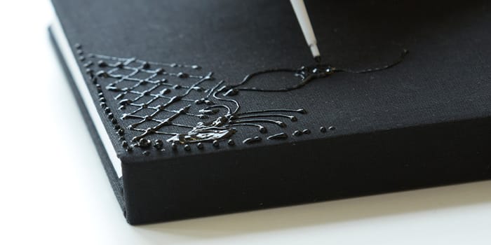 Closeup of a henna design handpainted onto a cloth cover Notebook