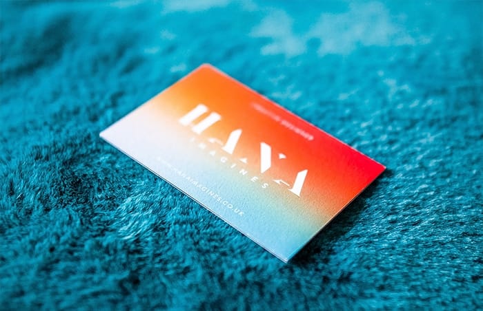 Orange and turquoise gradient business card by Hana Imagines on a turquoise rug