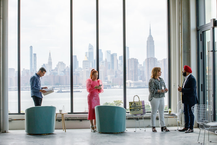People standing in front of a big window with a view of the New York skyline at The Lead Innovation Summit