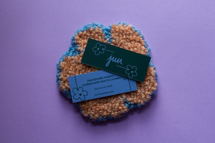 Double sided hang tags on a punch needle coaster by Juu
