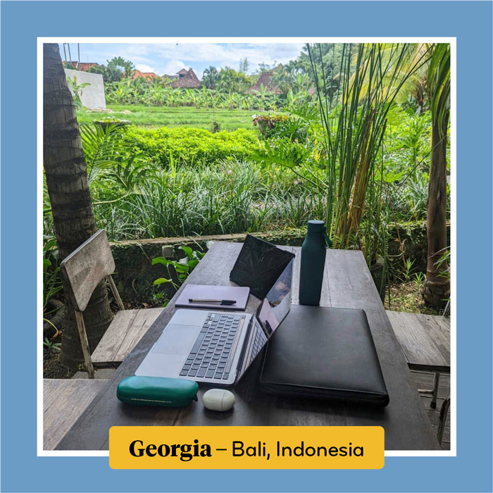 An open laptop in a cafe surrounded by fields in Bali.