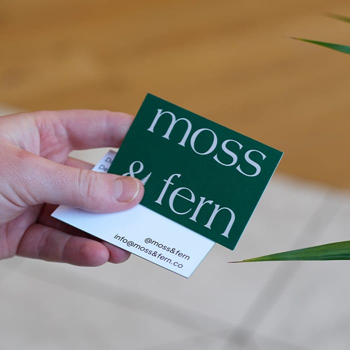 Luxe business cards with a rich green back and a green seam on the edge.